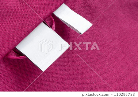 Blank white laundry care clothes label on red fabric texture background 110295758