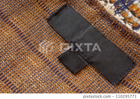 Blank black laundry care clothes label on brown fabric texture background Blank black laundry care clothes label on brown fabric texture background 110295771
