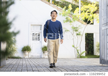 一名50多歲的男子背著背包行走 一名50多歲的男子背著背包行走 110299452
