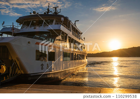 Ferry moored at Miyajimaguchi pier and sunrise Ferry moored at Miyajimaguchi pier and sunrise 110299538