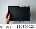 Hand hold black color blank paper on white background. 110300123