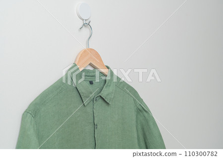 hanging shirt with wood hanger on wall 110300782