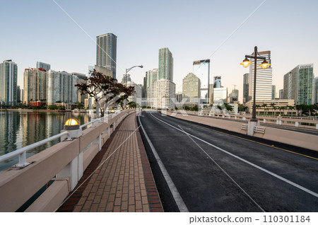 Brickell Key Bridge and City of Miami skyline at sunrise under clear blue sky. 110301184