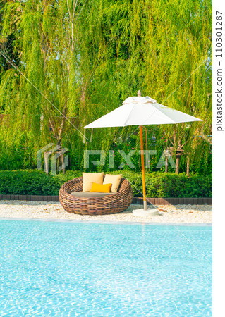 outdoor patio chair with pillow and umbrella around swimming pool 110301287