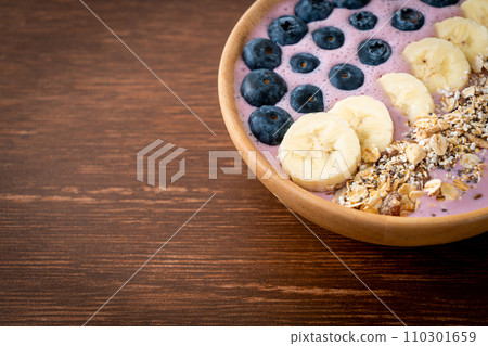 yogurt or yoghurt smoothie bowl with blue berry, banana and granola 110301659
