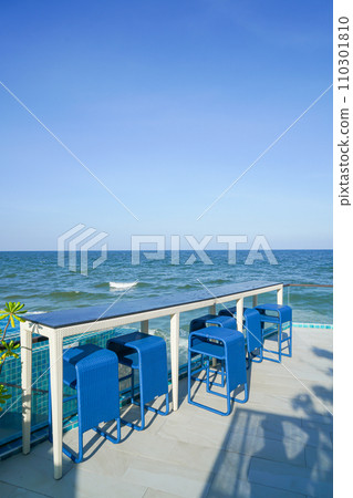 desk and bar stool near swimming pool with sea background 110301810