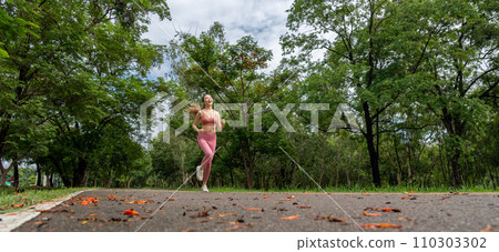 Young attractive happy Asian woman doing her morning run at running track of a locl park Young attractive happy Asian woman doing her morning run at running track of a locl park 110303302