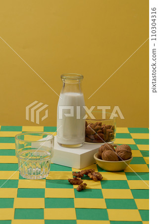 Square shaped podium with a unlabeled milk bottle and a glass bowl of almond placed on. Soybeans can help reduce the signs of sun damage on your skin Square shaped podium with a unlabeled milk bottle and a glass bowl of almond placed on. Soybeans can help reduce the signs of sun damage on your skin 110304316