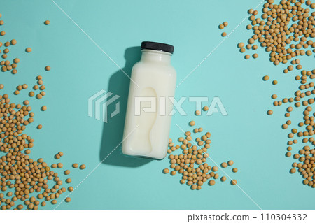 Concept of natural ingredients for branding mockup design with unlabeled milk bottle and soybeans decorated on blue background. Healthy organic food concept 110304332