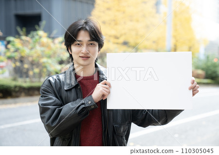 Young man with whiteboard in Nishi-Shinjuku in winter 110305045