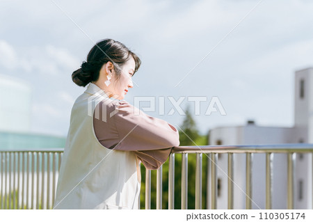 一位女商人一邊看著屋頂的風景一邊思考 一位女商人一邊看著屋頂的風景一邊思考 110305174