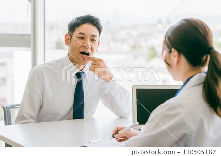 An Asian businessman consults a doctor about stomatitis (oral care, angular cheilitis, herpes labialis) An Asian businessman consults a doctor about stomatitis (oral care, angular cheilitis, herpes labialis) 110305187