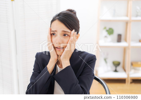 一個穿著西裝的女人抱著頭 110306980