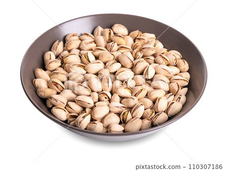 Roasted and salted pistachios in their shells, in a brown bowl. Crunchy roasted fruits of Pistacia vera, with opened shells and their seeds within. Snack food. Close-up, macro food photo. Roasted and salted pistachios in their shells, in a brown bowl. Crunchy roasted fruits of Pistacia vera, with opened shells and their seeds within. Snack food. Close-up, macro food photo. 110307186