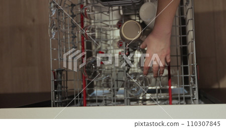 Woman open the dishwasher and takes a washed glasses from dishwasher machine. Cleaning house housewife. Close-up, top view. 110307845