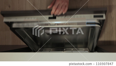 Woman open the dishwasher and takes a washed glasses from dishwasher machine. Cleaning house housewife. Close-up, top view. 110307847