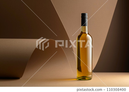 Bottle of white wine on a beige background. Bottle of white wine on a beige background. 110308400