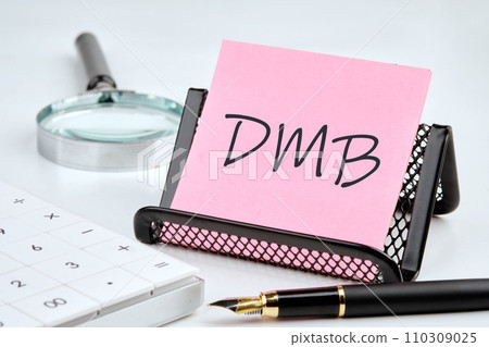 DMB word on the sticker on the stand on a white background next to a fountain pen, calculator and magnifying glass on a white background DMB word on the sticker on the stand on a white background next to a fountain pen, calculator and magnifying glass on a white background 110309025