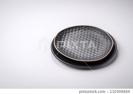 Empty round ceramic plate on a plain background, flatley with copy space 110309889