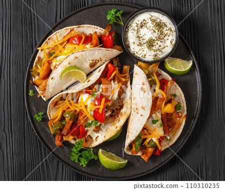 baked tex-mex chicken fajitas on a plate, top view 110310235