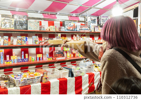 A woman shooting at a night shop 110312736