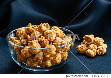View of sweet caramel almonds in transparent glass bowl. View of sweet caramel almonds in transparent glass bowl. 110312907