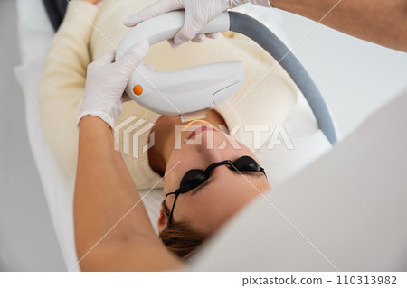 Phototherapy, photorejuvenation, IPL in a beauty salon. Care for a woman's face. 110313982