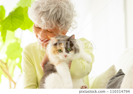 Japanese senior woman holding a cat at home (cat/owner) 110314794