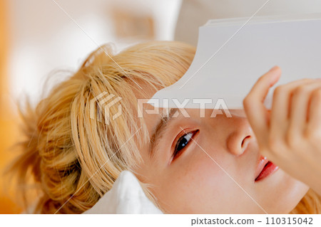Blonde woman peeking out from a book Blonde woman peeking out from a book 110315042