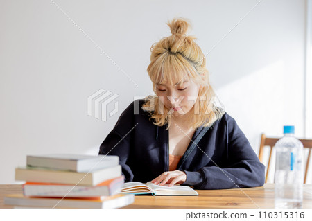 A young blonde woman studying towards her dreams A young blonde woman studying towards her dreams 110315316