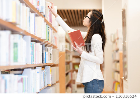 A woman picking a book 110316524