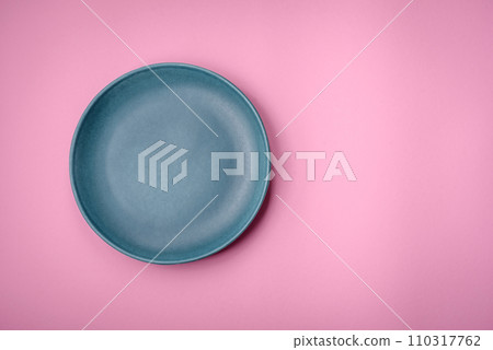 Empty round ceramic plate on a plain background, flatley with copy space 110317762