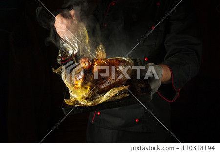 The cook removes the plastic pouch from the chicken by hand after baking or sous vide cooking. Concept of grilling a rooster in a restaurant kitchen. Black space for advertising The cook removes the plastic pouch from the chicken by hand after baking or sous vide cooking. Concept of grilling a rooster in a restaurant kitchen. Black space for advertising 110318194