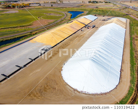 Drone view over grain storage piles being filled and covered Drone view over grain storage piles being filled and covered 110319422