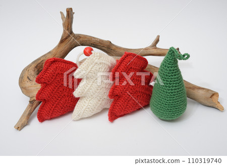 A group of knitted christmas trees and a piece of wood 110319740