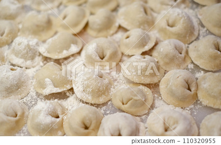 A pile of dumplings with flour on the table A pile of dumplings with flour on the table 110320955