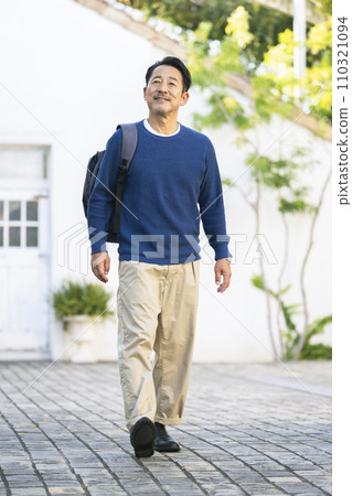 中年男子肩上背著背包走路 110321094