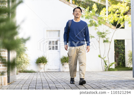 一個50多歲的男人肩上背著背包走路 110321294