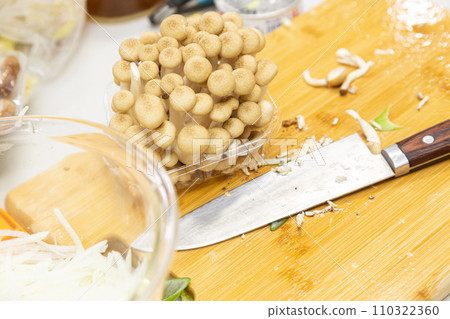 Shimeji mushrooms and knife on a cutting board 110322360