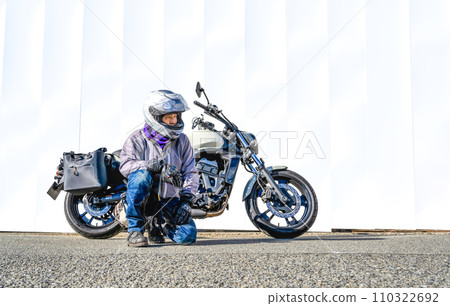 Large American motorcycle and male rider 110322692