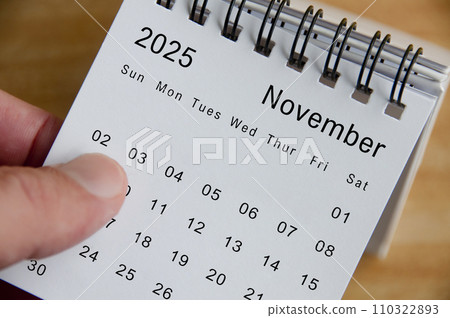 Close up view of November 2025 Calendar on wooden desk background. Monthly calendar concept. Close up view of November 2025 Calendar on wooden desk background. Monthly calendar concept. 110322893