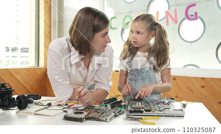 Young smart teacher teaching student about part of electronic board. Erudition. 110325087