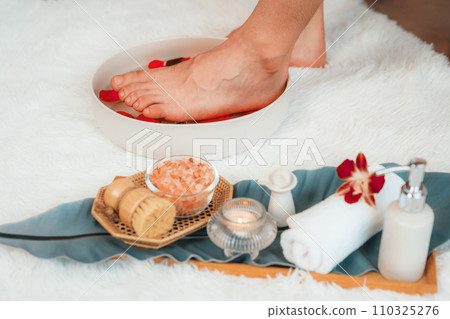 Woman indulges in blissful foot massage at luxurious spa salon. Quiescent Woman indulges in blissful foot massage at luxurious spa salon. Quiescent 110325276