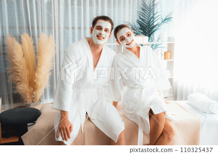 Blissful couple in bathrobe with facial cream mask. Quiescent 110325437
