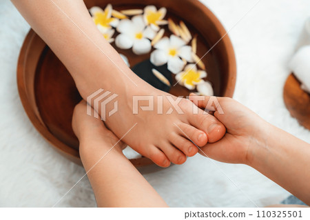 Woman indulges in blissful foot massage at luxurious spa salon. Quiescent Woman indulges in blissful foot massage at luxurious spa salon. Quiescent 110325501