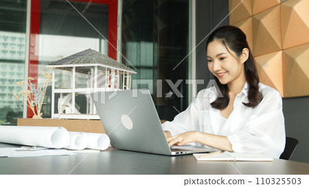 Young beautiful engineer checking roof material and using laptop. Manipulator. 110325503