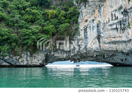 Vietnam: A person rows a kayak in Halong Bay, which is surrounded by strangely shaped rocks, and arrives at a tourist spot. Vietnam: A person rows a kayak in Halong Bay, which is surrounded by strangely shaped rocks, and arrives at a tourist spot. 110325743