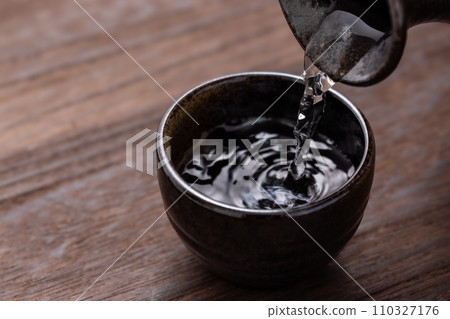 Pour sake into the choko. Pour sake into the choko. 110327176