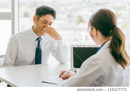 Male businessman being examined by a female doctor at a hospital (medical checkup, diagnosis, medical examination) Male businessman being examined by a female doctor at a hospital (medical checkup, diagnosis, medical examination) 110327772