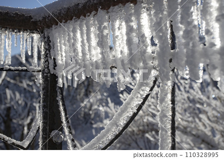 icicles and Snow on the old balcony railing 110328995